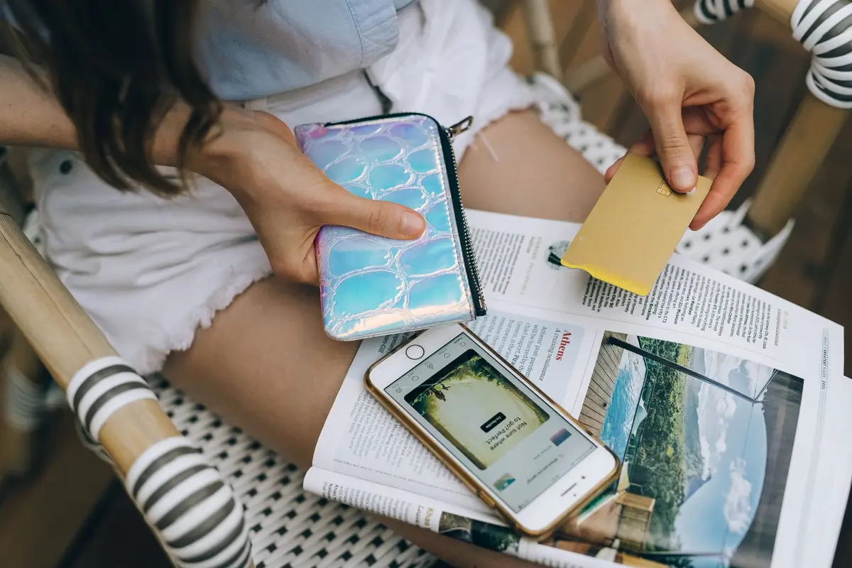 Woman paying online with a phone and a card