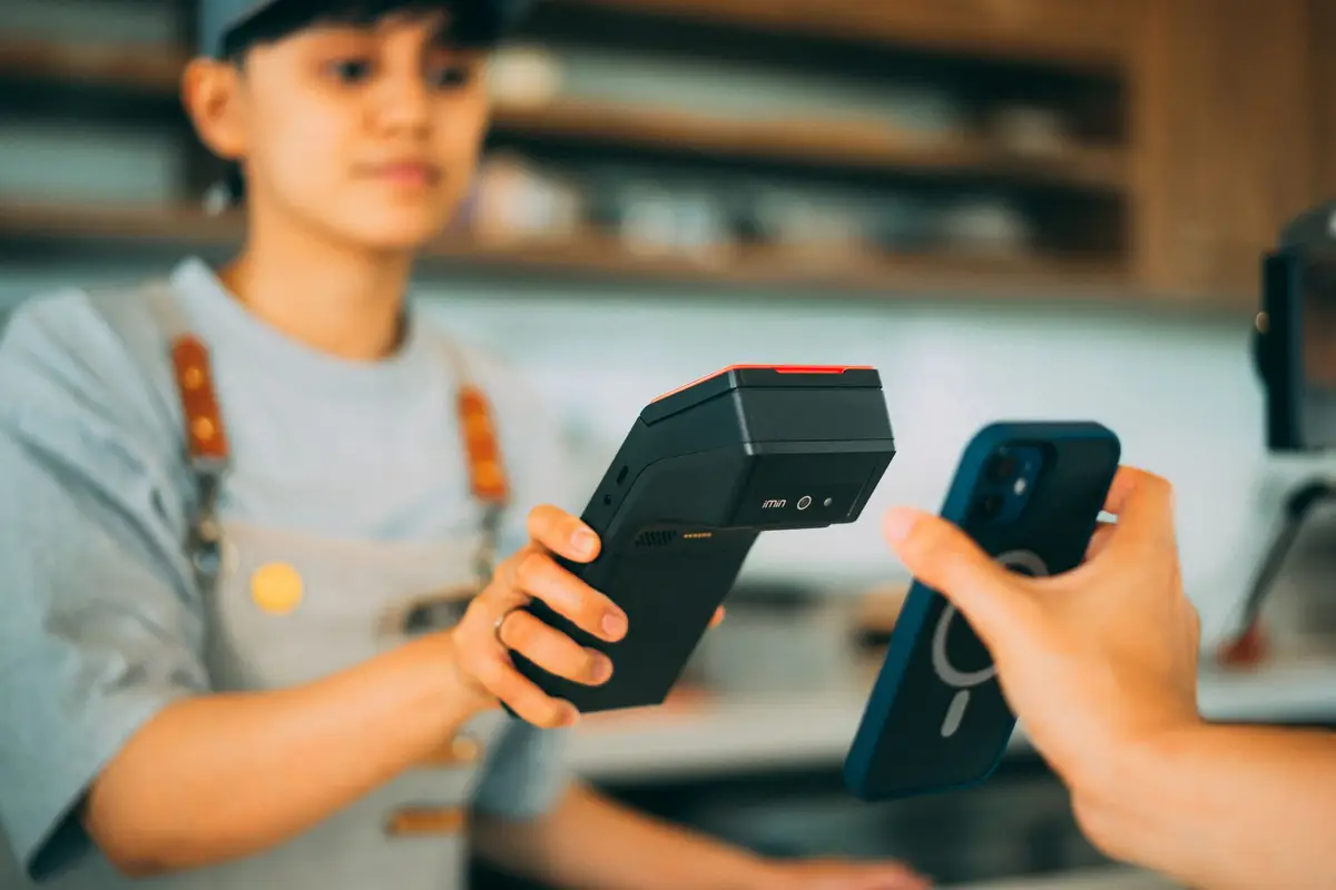 Cashier taking a contactless payment at a counter