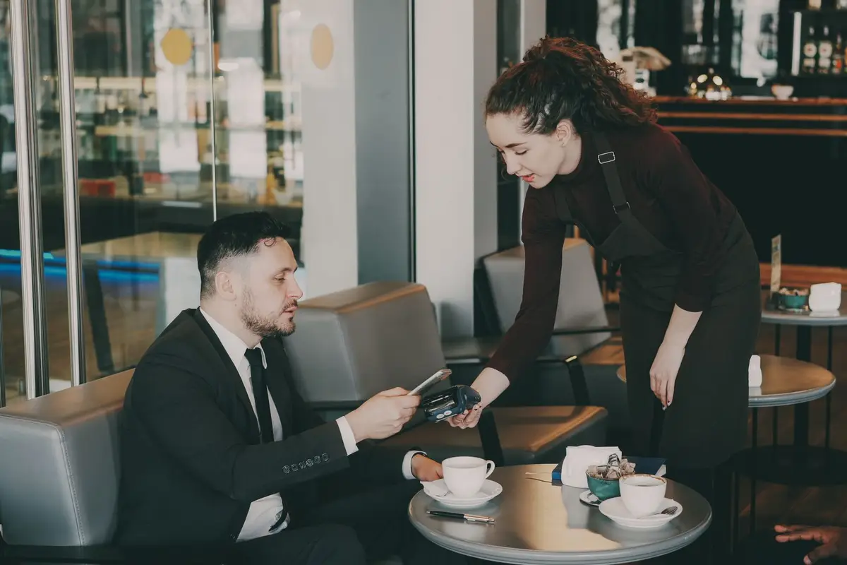 Customers paying by card in a cafe