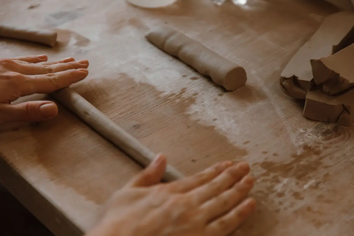Hands shaping clay on a wheel