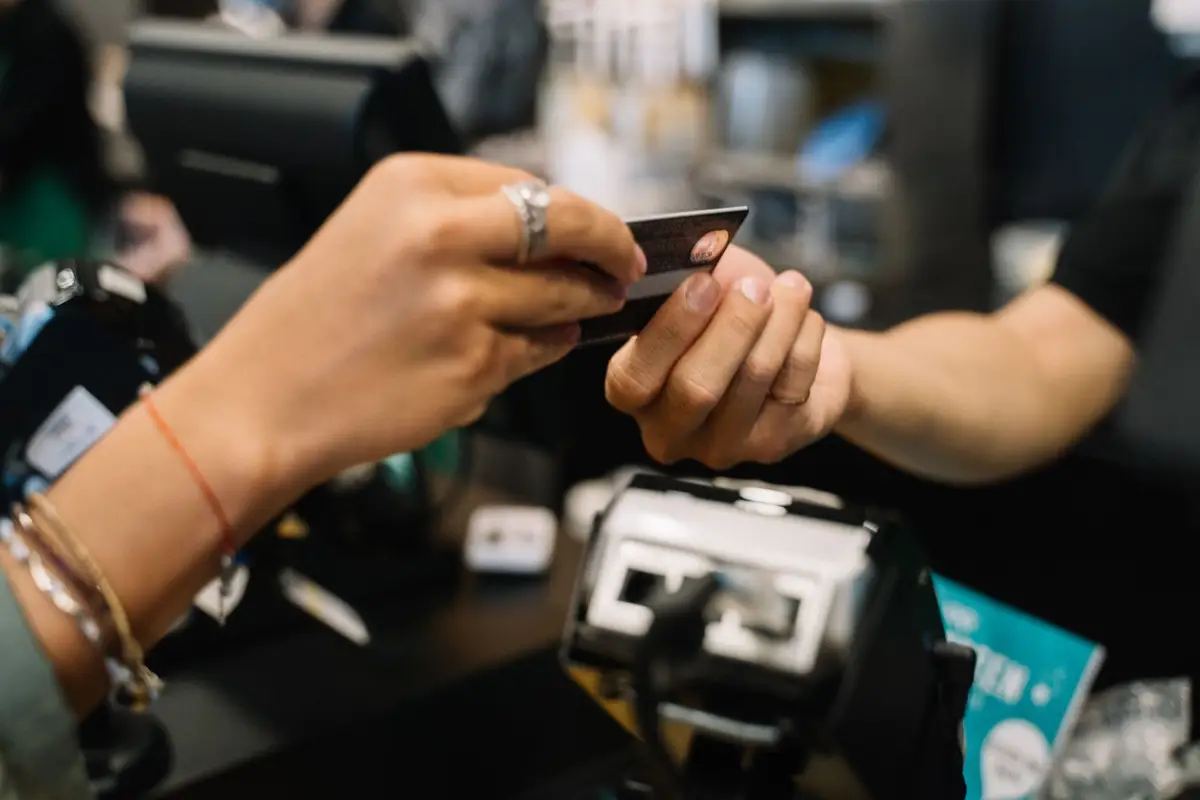Hands completing a card payment at a counter