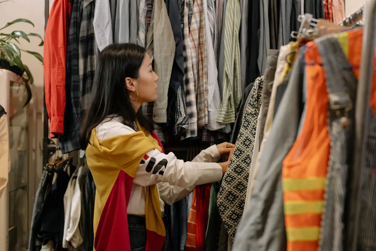 Woman browsing colourful clothes in a vintage store