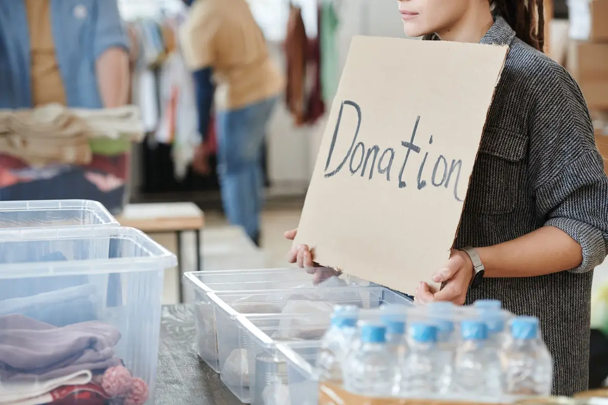Volunteer holding a donation sign at a charity event