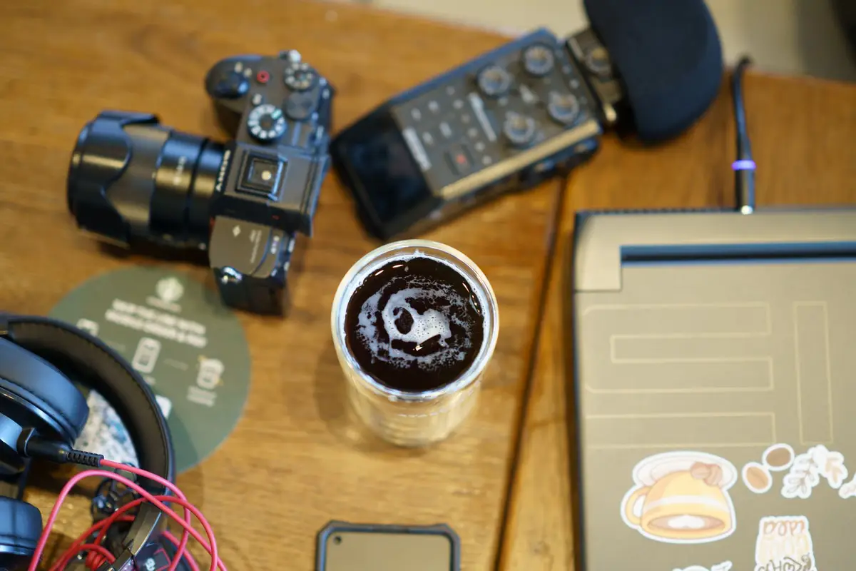 Creator desk with a camera, headphones and coffee