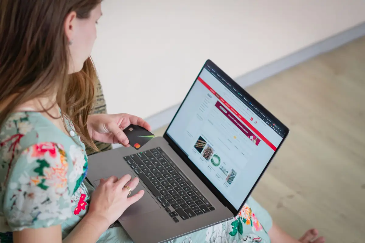 Person shopping online with a laptop and a credit card