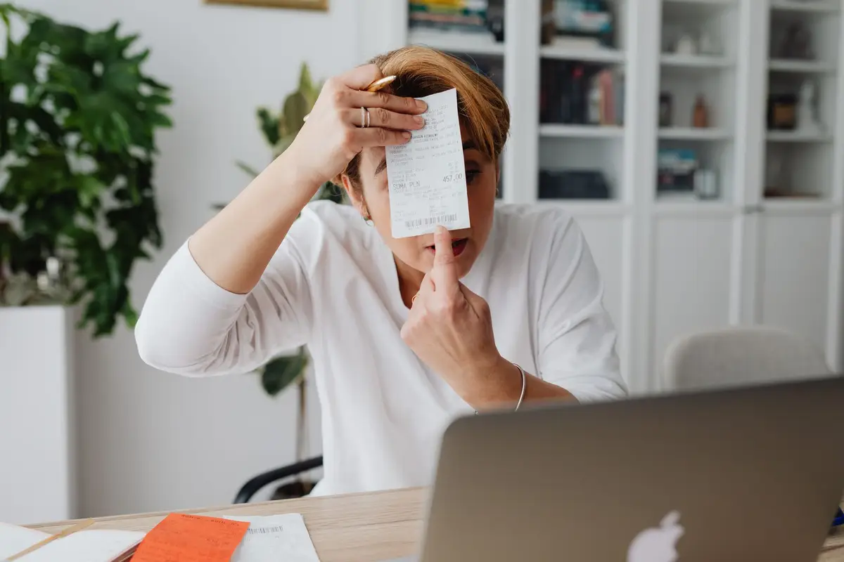 Freelancer reviewing a receipt at a home office