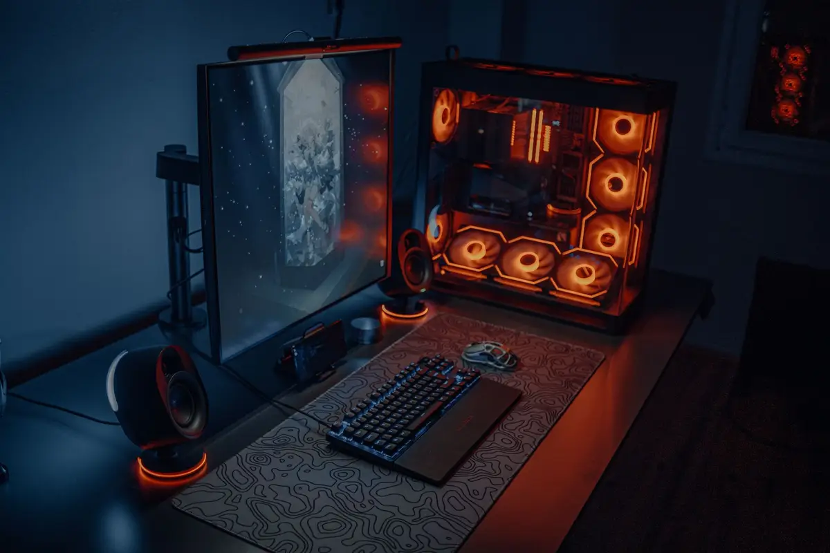 Gaming desk with a lit keyboard and monitors