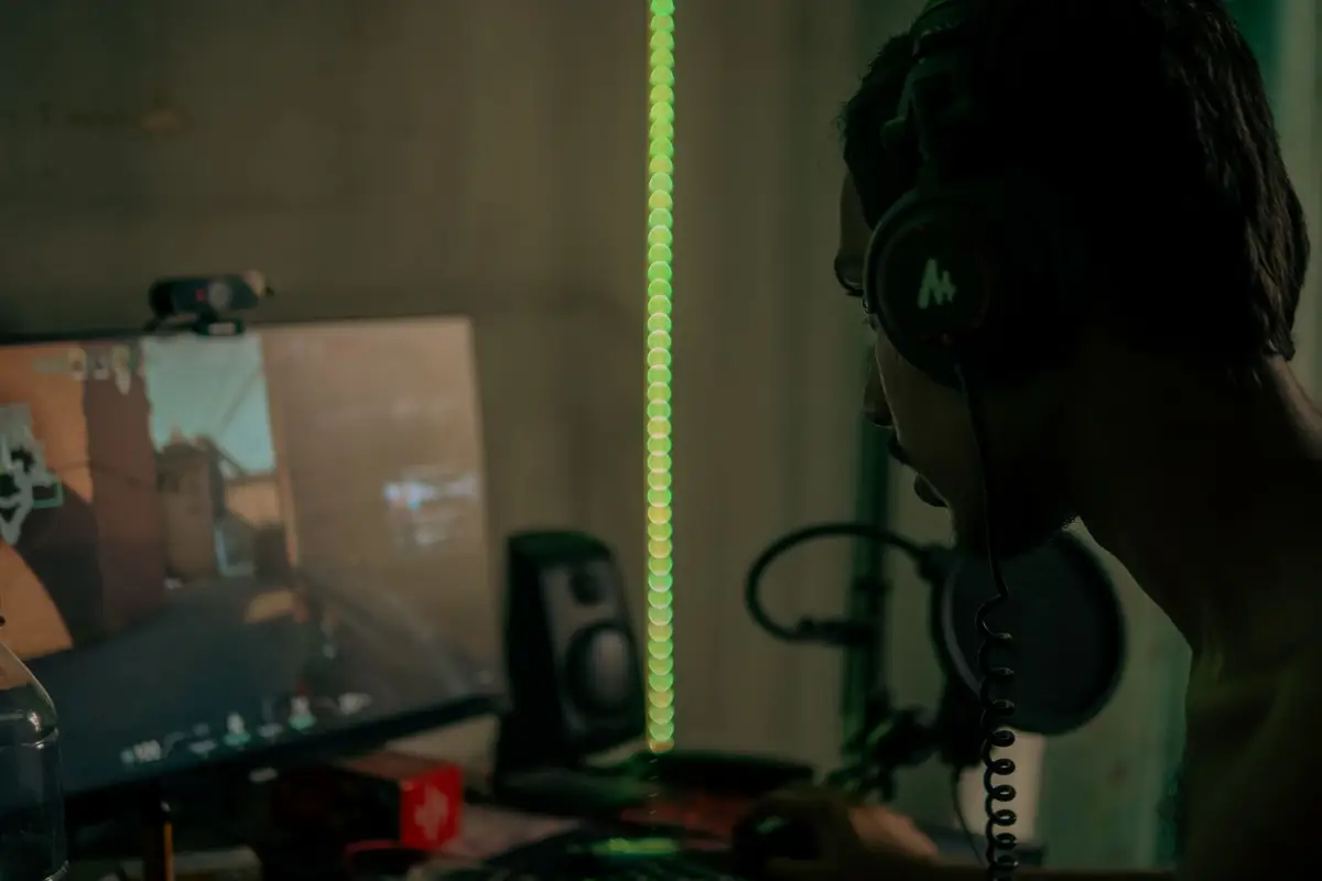 Streamer with a headset playing at a desktop PC