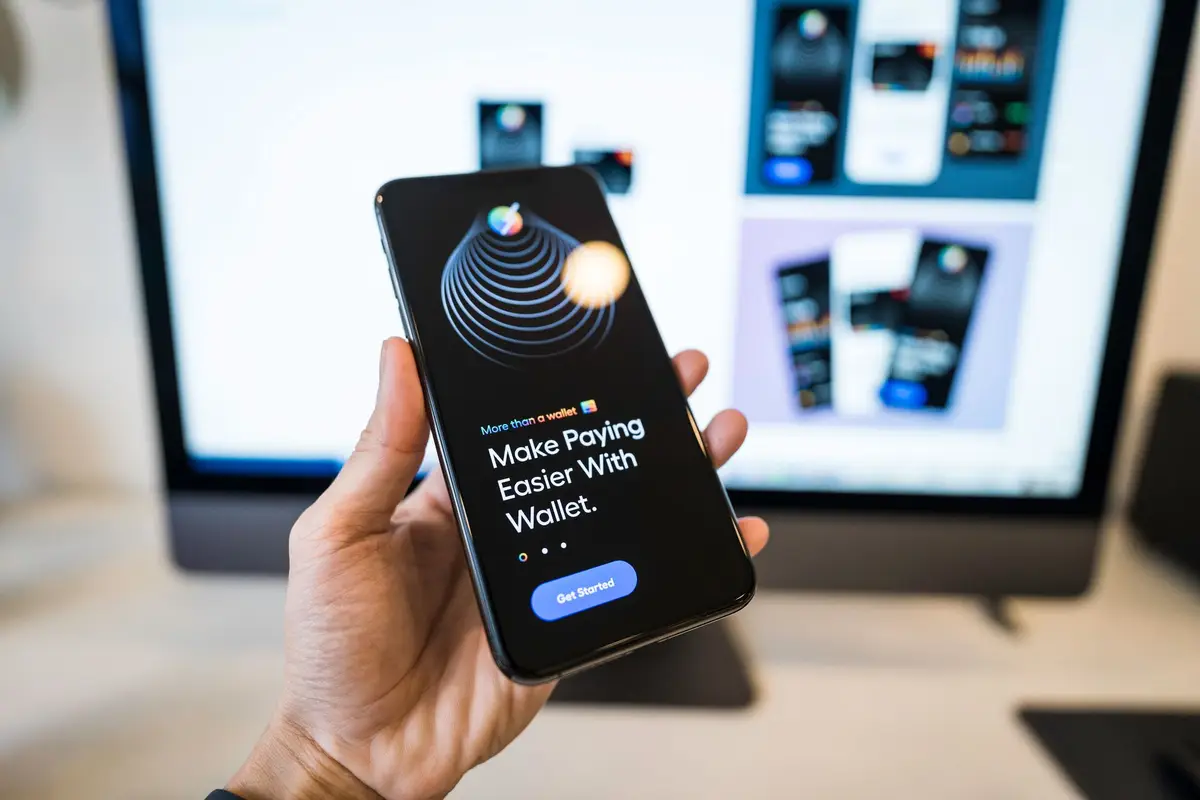 Hand holding a phone showing a digital wallet app