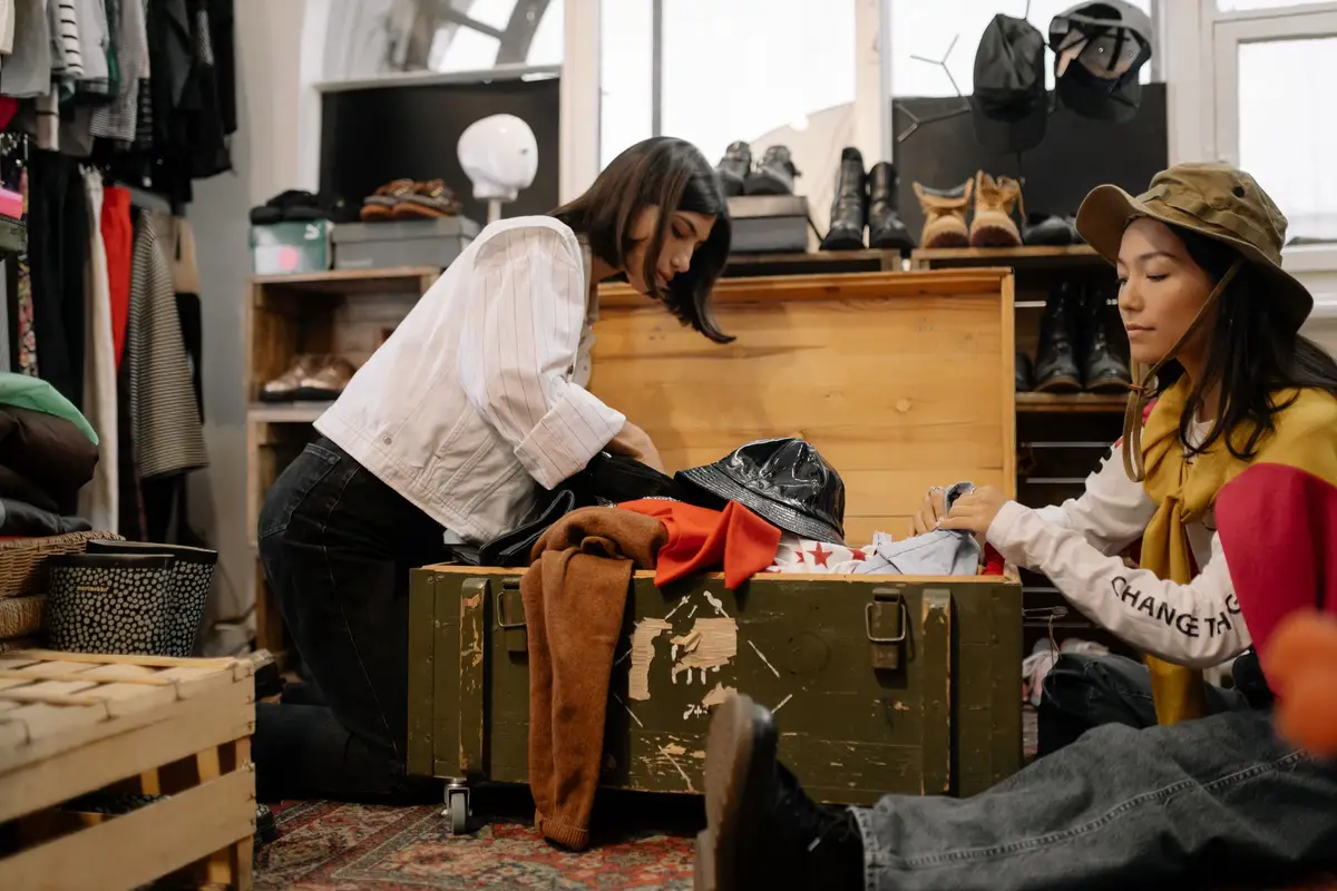 Two women sorting vintage clothes in a thrift shop